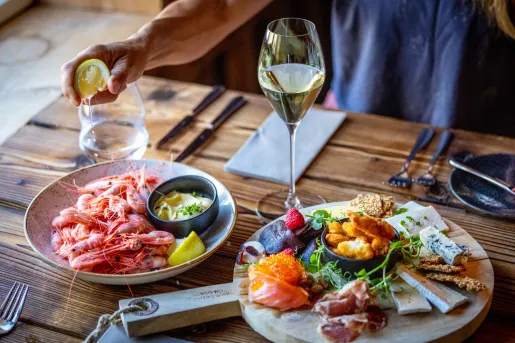 Plate with boiled seafood, with a charcuterie board next to it