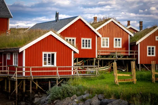 Cluster of red cabin buildings next to a river