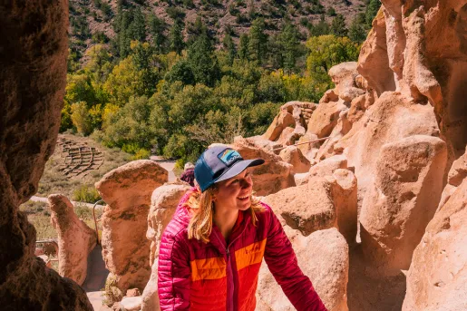 Woman smiling while climbing stairs into a cave