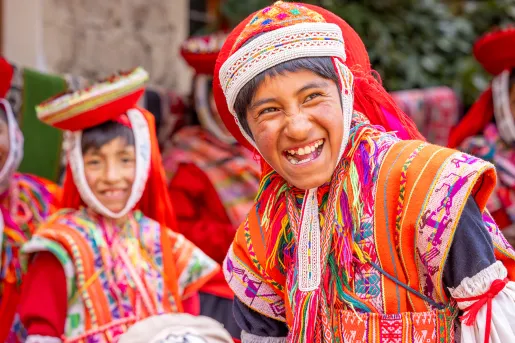 Boy in traditional attire, smiling with a group of other boys behind him