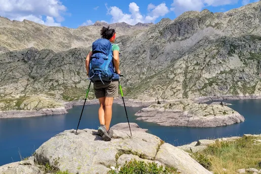 A hiker stops at a lake to look at the view
