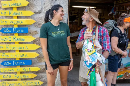 Man and woman smiling next to yellow and blue arrow signs