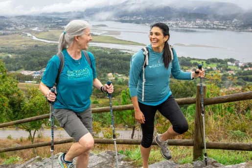 Two women smiling while walking up stairs on a hill