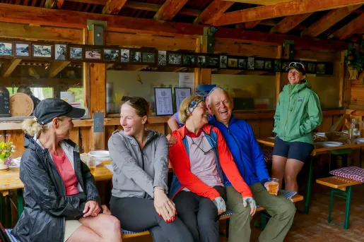 Group of people sitting on a bench indoors, laughing and smiling