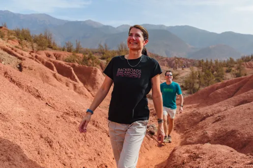 Woman smiling while walking on a trail in a canyon