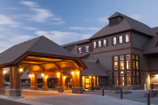 Exterior view of hotel building with large driveway illuminated by warm lights