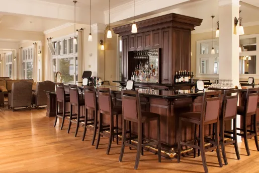 Bar and lounge with a center shelve full of alcohol bottles and spirits