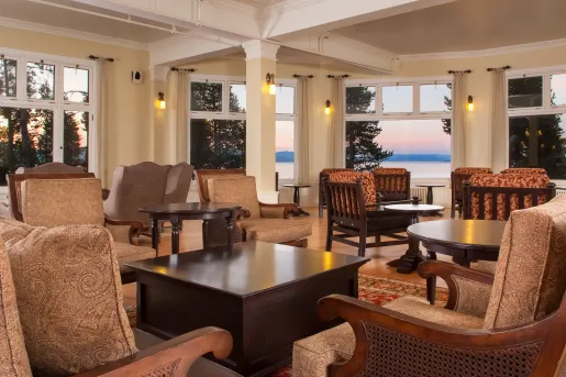 Indoor seating area and lounge with cushioned chairs and dark brown tables