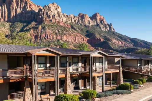 Exterior view of two-story hotel building with large stone pillars
