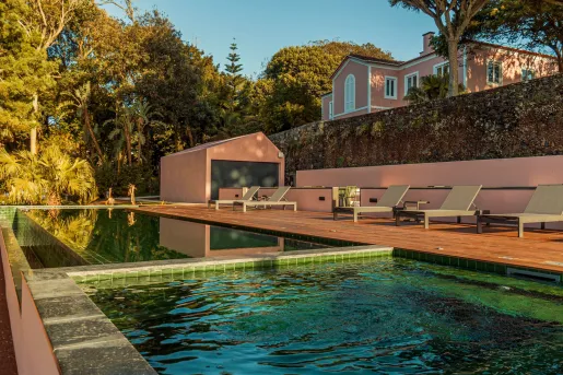 Outdoor pool with stone walls and reclining chairs