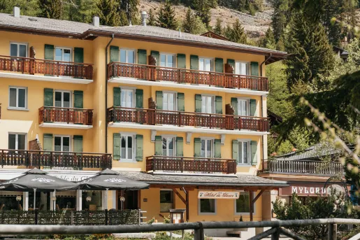 The exterior of Hôtel du Glacier, known for its yellow facade and green shutters.