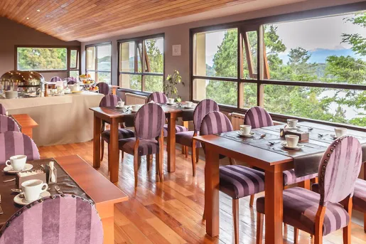 Dining area with square dining tables and red, cushioned chairs