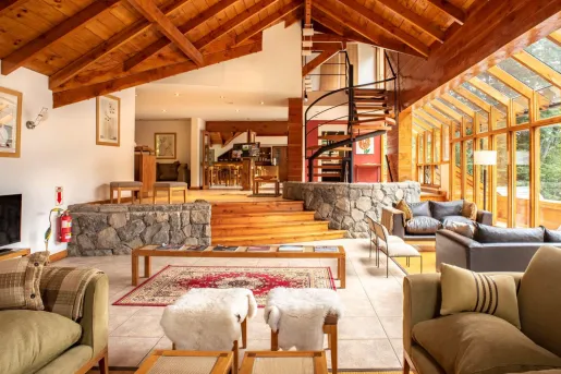 Cabin living room with cushioned sofas and a staircase in the back