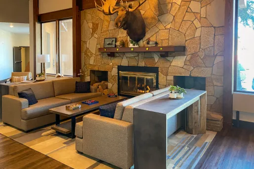 Stone wall with a fireplace and two beige couches in front