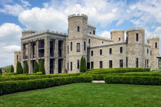 Exterior view of a stone castle with a large lawn in front