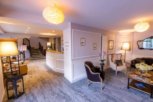 Hotel lobby area with cushioned sofas and couches, and round light fixtures