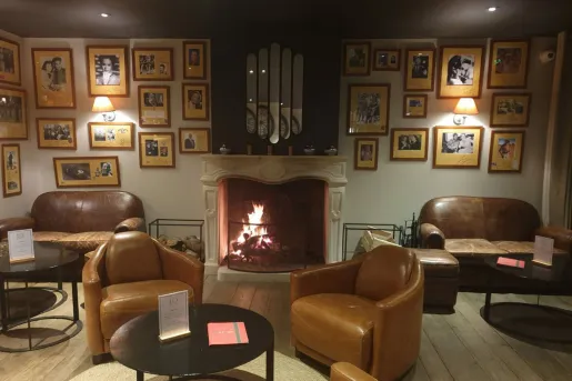 Dimly lit lounge area with leather couches in front of a fireplace