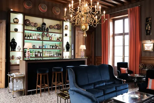 Bar and lounge with blue sofas and a bar counter with alcohol on shelves