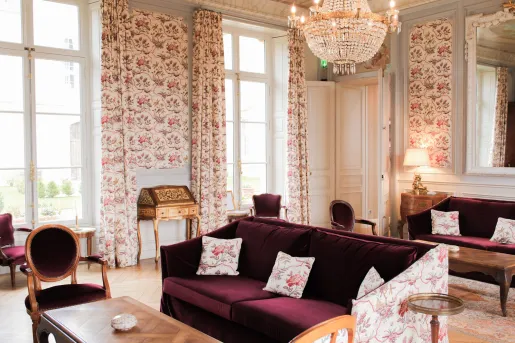 Room lobby with red, cushioned sofas and flower patterned curtains