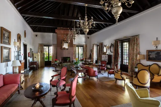 Lobby and lounge area with red and beige chairs surrounding small coffee tables