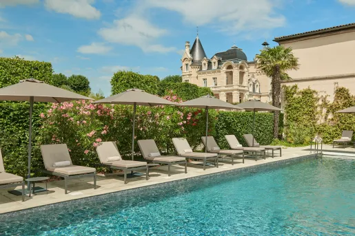 Outdoor pool surrounded by trimmed bushes