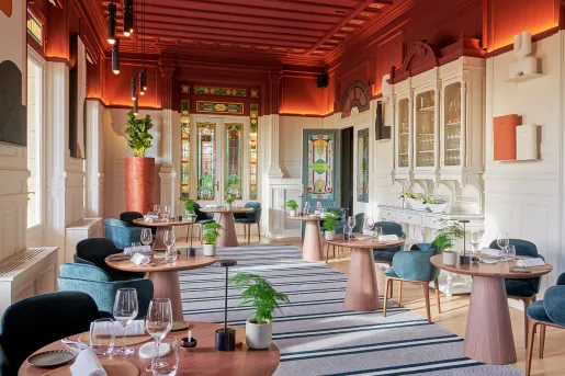 Lounge and dining area with circular tables and blue chairs
