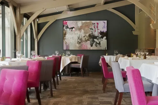 Restaurant with white dining tables and pink and gray chairs