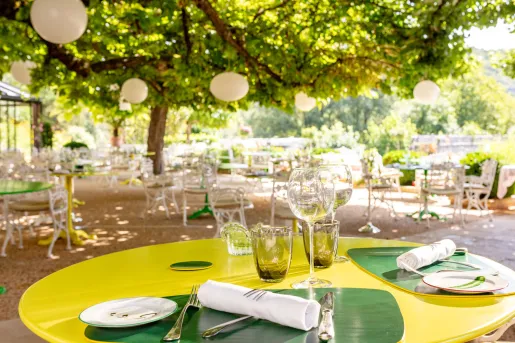 Outdoor patio and dining area with circular, yellow tables and wine glasses