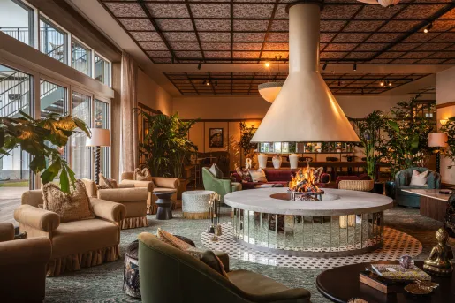 Lounge and seating area with cushioned chairs and a firepit in the center