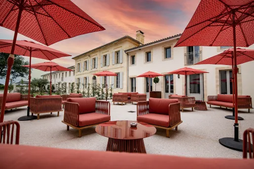 Outdoor patio with red, cushioned chairs and red umbrellas