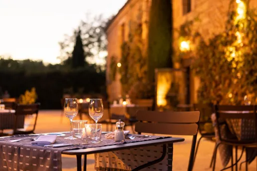 Outdoor patio with dimly lit lights, and metal tables in front