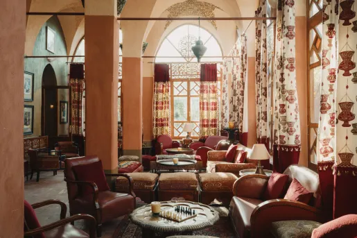 The Eastern Bar lounge inside the Al Moudira Hotel located on the West Bank of the Nile in Luxor, Egypt features traditional architecture with high vaulted arches and hand-painted murals.