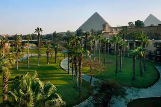 Palm tree-lined paths meander through the expansive garden wing with lush landscaped grounds at the Marriott Mena House, Cairo, located right at the base of the Giza Plateau.