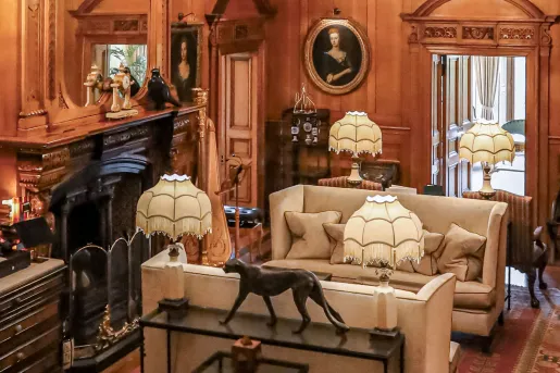 Room with antiques along the wall and 2 beige couches