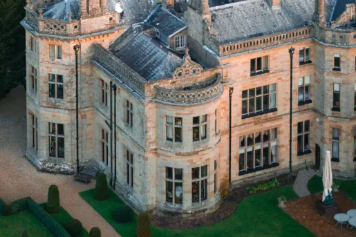 Aerial view of castle-like building with a trimmed lawn in front