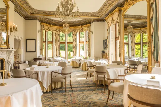 Dining area in a restaurant with circular dining tables and beige chairs