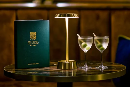 Circular, glass table with two glasses with alcholic drinks