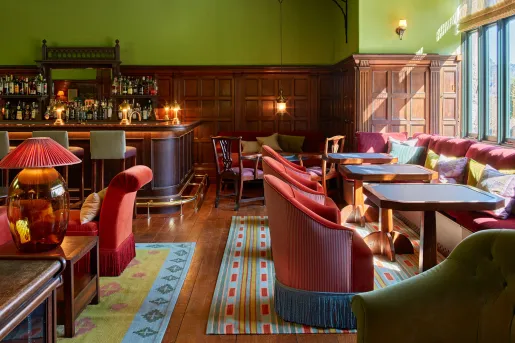 Restaurant with cushioned chairs surrounding square dining tables