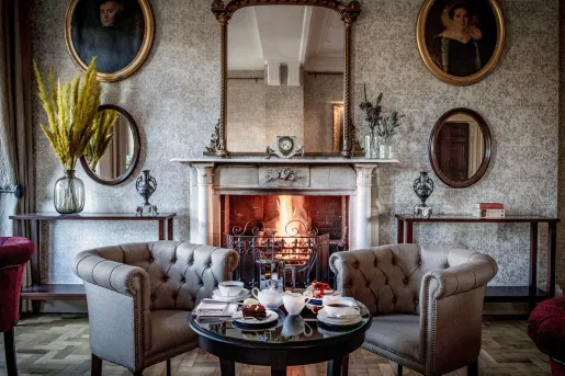 Lounge and seating area with two cushioned chairs in front of a fireplace