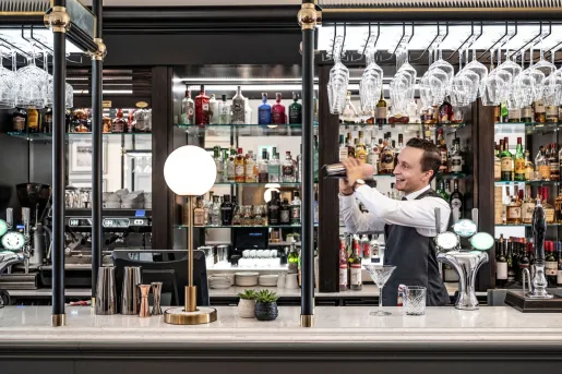 Bartender mixing a drink behind a bar counter