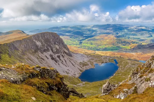 Sky view of valley with tall mountains and a lake in the center