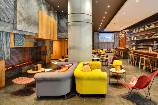 Lounge area with cushioned sofas next to large fireplaces