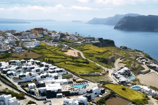 Overlook of Santo Pure Oia with rolling hills and a distant bay.