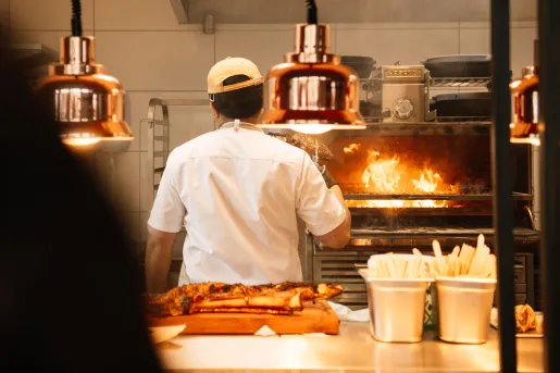 A chef working in the restaurant kitchen with a live-fire grill at the KG Hotel in Klaksvík, Faroe Islands. 