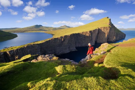 Person hiking on a slanted, grassy hill
