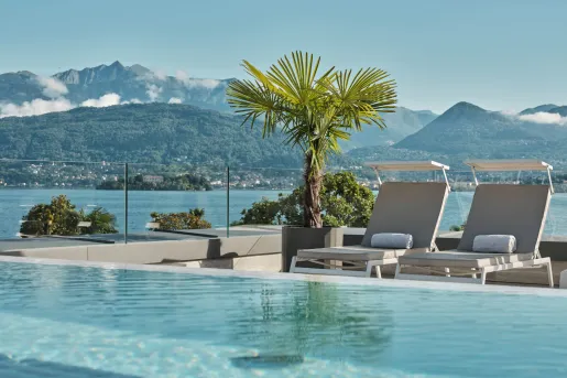 The rooftop panoramic infinity pool with modern sun loungers at the Boutique Hotel Stresa on the shores of Lake Maggiore.