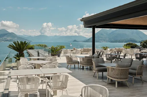 The rooftop terrace of the Boutique Hotel Stresa on Lake Maggiore, features contemporary white outdoor furniture and panoramic views.