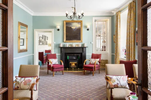 Living room area with cushioned chairs in front of a black fireplace