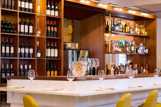 Bar counter with wooden shelves and bottles of wine