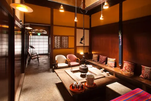 Japanese-style room with a table in the center and wooden benches surrounding the perimeter of the room